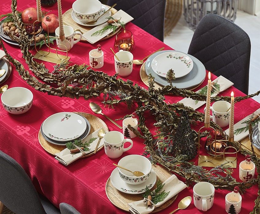"Weihnachtsessen mit rotem Tischtuch und goldenem Besteck"